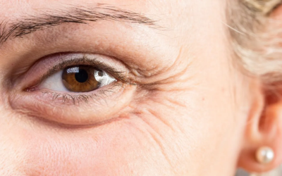 Close-up of a brown eye with crow's feet wrinkles around the eye and light skin.