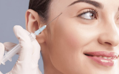 Close-up of a clinician injecting lip filler into a woman's lips, with a gloved hand holding a syringe.