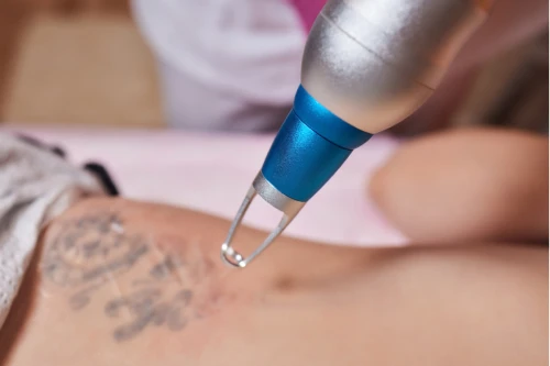 Woman receiving a cosmetic facial injection near the eyebrow while resting with eyes closed (gloved hands and syringe shown) .